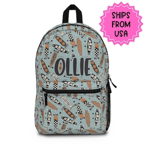 May include: A light blue backpack featuring a pattern of skateboards in black, brown, and white. The name "OLLIE" is printed on the front. The backpack has a black handle, a front pocket, and a side mesh pocket.