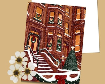 May include: A Christmas card featuring a brownstone building with holiday decorations. The illustration shows wreaths on the doors and windows, a decorated Christmas tree, and falling snow. A red bow and garland adorn the steps.