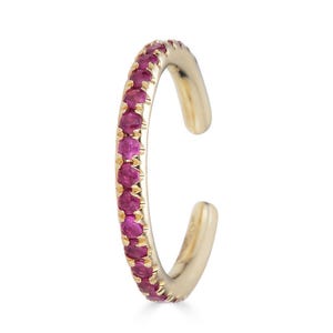 Puede incluir: Un pendiente de aro de oro con una fila de pequeñas piedras preciosas rosas.