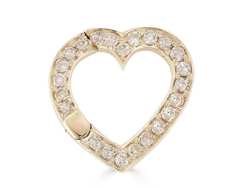May include: A gold-colored heart-shaped pendant with a clasp. The pendant is encrusted with small, clear gemstones around the heart's outline. The clasp is located on the left side of the heart.