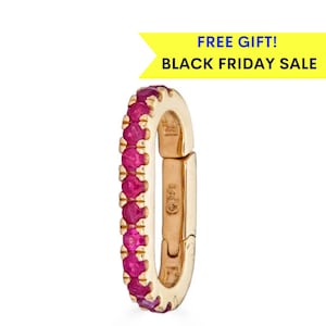 May include: Gold hoop earring with a row of ruby red stones around the edge. The hoop is hinged and has a clasp closure.