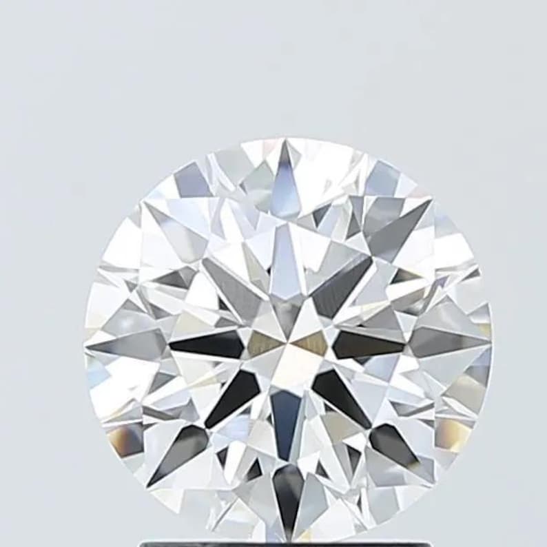 Pu&ograve; includere: Un diamante rotondo a taglio brillante con numerose sfaccettature, che riflettono la luce. Il diamante &egrave; trasparente e incolore, con un alto grado di brillantezza. L'immagine &egrave; un primo piano, che mostra i dettagli della gemma.