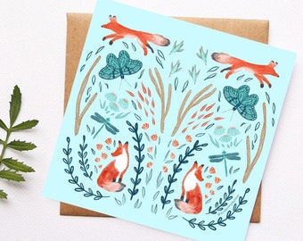 May include: A blue background with a repeating pattern of foxes, butterflies, dragonflies, and flowers. The foxes are orange and white, the butterflies are blue and green, the dragonflies are blue, and the flowers are red and white.