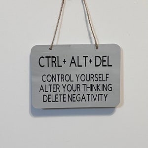 May include: A gray wooden sign with the text "CTRL + ALT + DEL" and the words "Control Yourself, Alter Your Thinking, Delete Negativity" printed in black.