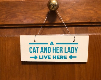 A Cat and Her Lady live here. Wood, Hand Painted, Vinyl Lettering, Hanging, Fun cat sign. 7" x 3".