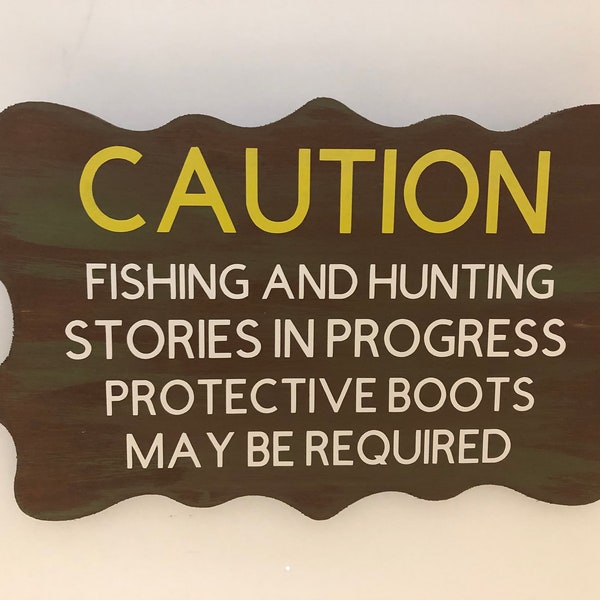 Caution Fishing and hunting stories in progress protective boots may be required. Wood, Hanging, Hand Painted, Vinyl lettered. 7.5" x 5".