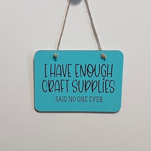 May include: A light blue wooden sign with black text that reads "I have enough craft supplies - said no one ever".