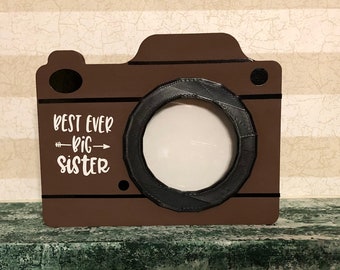 Big sister Camera shaped picture frame. 3D printed lens. Hand Painted, Vinyl Lettering. 5 3/4inx4 1/2". Holds 2.8"x2.8" Picture.