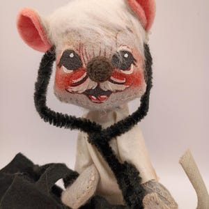 May include: A vintage handmade mouse doll with a white head, pink ears, and a brown nose. The mouse wears a white shirt and has a black stethoscope around its neck. The doll has a black cape and a long, curved tail.