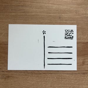 Puede incluir: Una postal blanca con ilustraciones en tinta negra. El dise&ntilde;o incluye una flor, una l&iacute;nea vertical, cuatro l&iacute;neas horizontales y un peque&ntilde;o cuadrado abstracto. La postal est&aacute; en blanco a la izquierda.