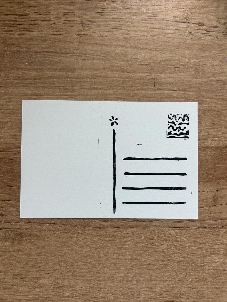 Puede incluir: Una postal blanca con ilustraciones en tinta negra. El dise&ntilde;o incluye una flor, una l&iacute;nea vertical, cuatro l&iacute;neas horizontales y un peque&ntilde;o cuadrado abstracto. La postal est&aacute; en blanco a la izquierda.