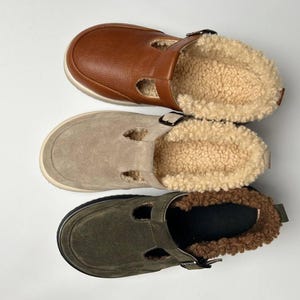 Puede incluir: Tres pares de zapatos para mujer con empeines de ante de diferentes colores y suela blanca. Los zapatos tienen una correa en la parte superior con cierre de hebilla. Los zapatos est&aacute;n forrados con un material blanco esponjoso.