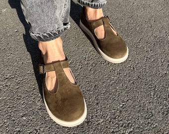 Mary Janes de ante oliva Barefoot: planos con tira en T y puntera ancha