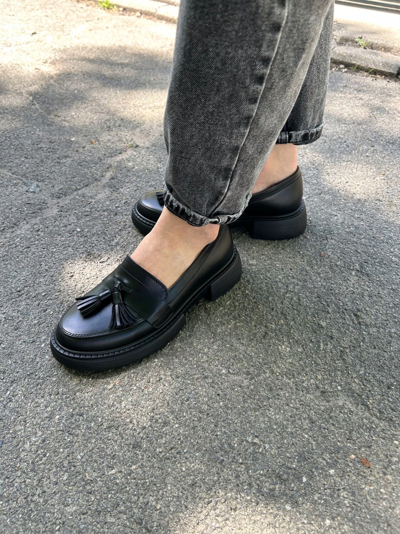 May include: Black leather loafers with a tassel detail and a chunky platform sole.