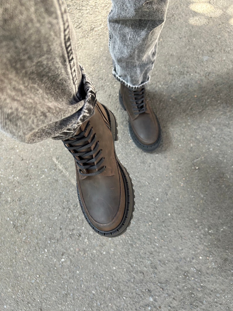 May include: Brown leather lace-up boots with a chunky black rubber sole.