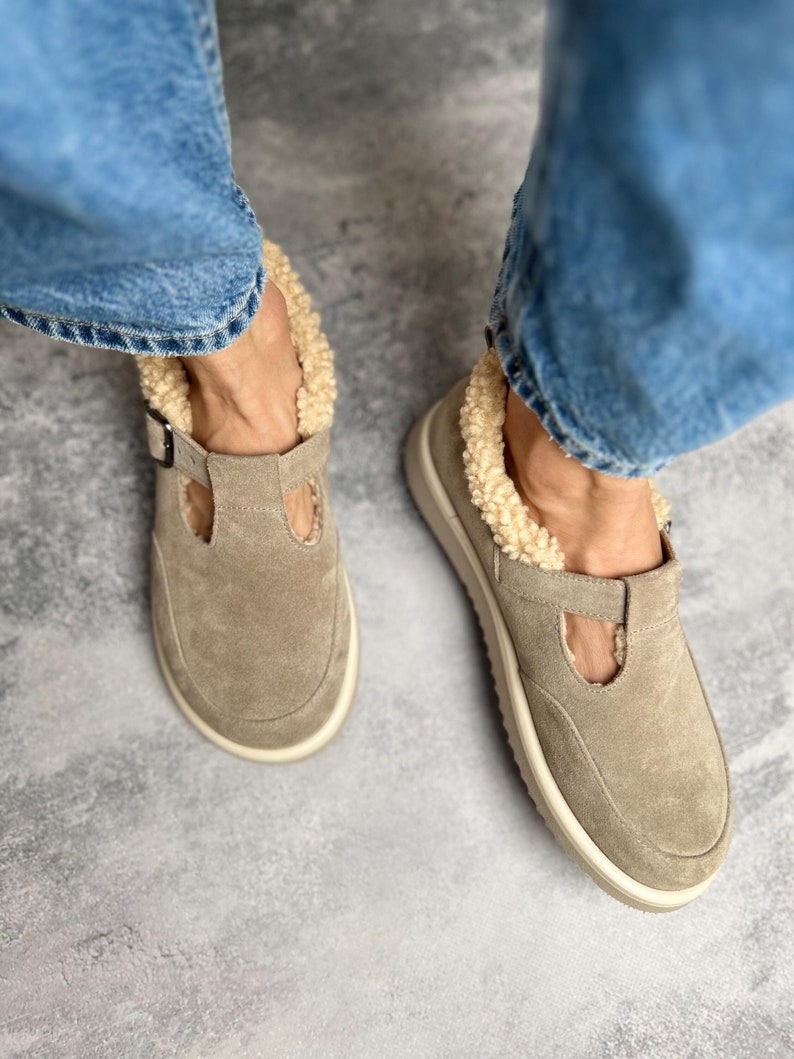 Puede incluir: Zapatos de ante beige con cierre de hebilla y forro de piel sint&eacute;tica. Los zapatos tienen una suela de plataforma blanca.