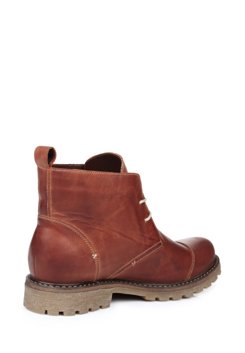 May include: Brown leather ankle boots with laces. The boots have a rugged sole and a slightly pointed toe.