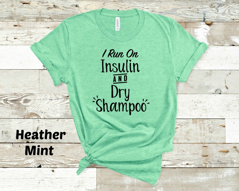 Puede incluir: Una camiseta verde menta jaspeada con el texto "I Run On Insulin And Dry Shampoo" impreso en negro.