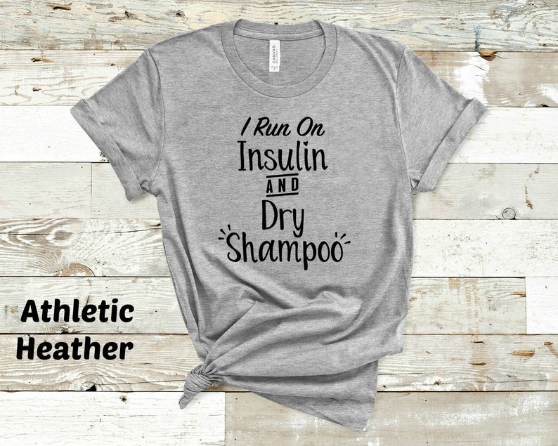 Puede incluir: Camiseta gris con el texto "I Run On Insulin And Dry Shampoo" impreso en negro.