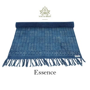 May include: A blue cotton yoga mat with a white geometric pattern and fringe. The mat is rolled up and the text "Essence" is printed below it. The text "Yoga Kargha" is printed in the top right corner.