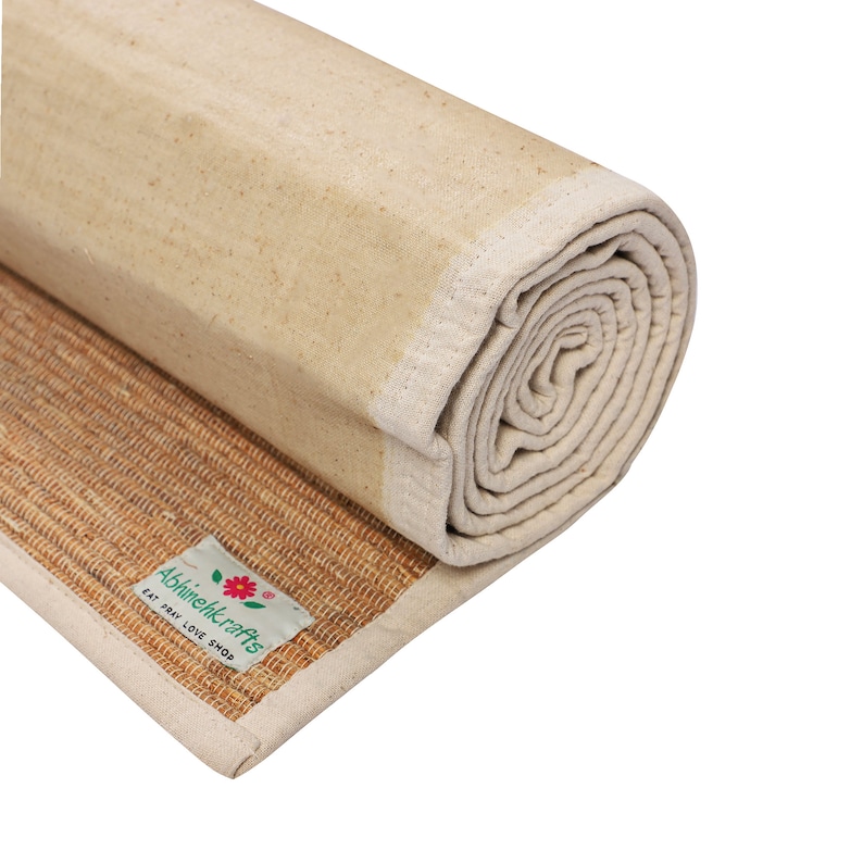K&ouml;nnte beinhalten: Eine aufgerollte Yogamatte aus Naturfasern mit einer wei&szlig;en Baumwoll-Au&szlig;enschicht. Die Matte hat ein Etikett mit der Aufschrift "Abhineilkrafts Eat Pray Love Shop".