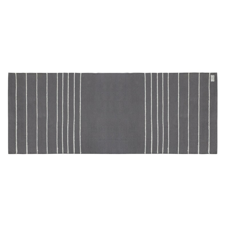 May include: A gray and white striped runner rug. The rug has a subtle texture and is perfect for adding a touch of modern style to any room.