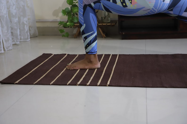 May include: A brown yoga mat with white stripes. The mat is made of a natural material and has a textured surface.