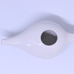 Puede incluir: Ducha nasal de cerámica blanca con una abertura redonda y un pico.