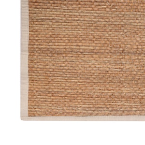 K&ouml;nnte beinhalten: Ein nat&uuml;rlicher gewebter Teppich mit einem beigefarbenen Rand. Der Teppich ist aus Naturfasern gefertigt und hat einen rustikalen Look.
