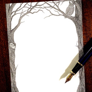 May include: A black and white pen and ink drawing of a tree with an owl perched on a branch. The drawing is on a white sheet of paper with a brown wooden background.