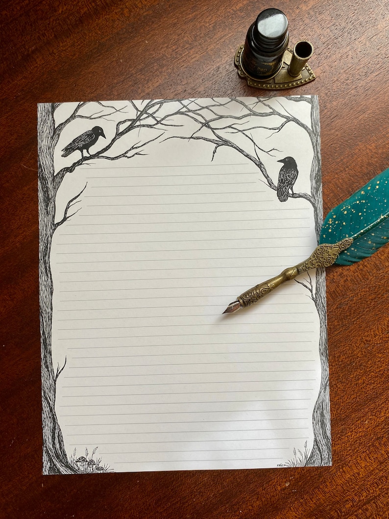 May include: A white sheet of lined paper with a black and white illustration of bare trees and crows on the edges. A quill pen and inkwell are on the table next to the paper.
