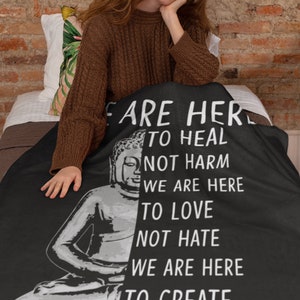 May include: Black throw blanket with a white image of a meditating Buddha and text that reads "We are here to heal not harm, we are here to love not hate, we are here to create not destroy."