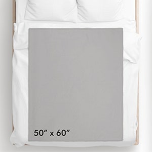 May include: A gray throw blanket on a queen-sized bed. The blanket measures 50 inches by 60 inches.