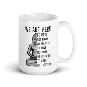 May include: White ceramic mug with a black and white image of a meditating Buddha. The text "WE ARE HERE TO HEAL NOT HARM WE ARE HERE TO LOVE NOT HATE WE ARE HERE TO CREATE NOT DESTROY" is printed on the mug.