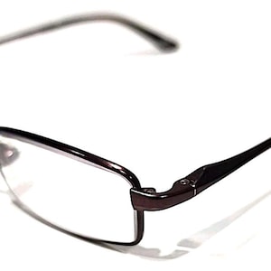 May include: A pair of eyeglasses with a dark brown frame and clear lenses. The glasses have a rectangular shape and a thin, sleek design. The temples are also dark brown and extend back to the ear.