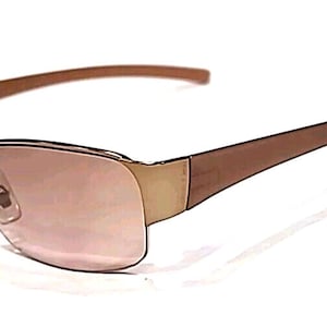 May include: Brown-framed sunglasses with a rectangular lens shape. The lenses have a pinkish tint, and the frames are a mix of brown and gold tones. The sunglasses have a sleek, modern design.