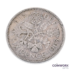 以下が含まれることがあります： 1963 年の銀貨 6 ペンス。"FID DEF SIX PENCE 1963" と刻印され、バラ、アザミ、クローバーの花柄がデザインされています。