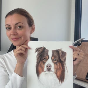 May include: A rectangular white paper print featuring a detailed colored pencil drawing of a brown, white, and tan Australian Shepherd dog. The dog's name, Jasper, is printed in black cursive script at the bottom left of the paper.