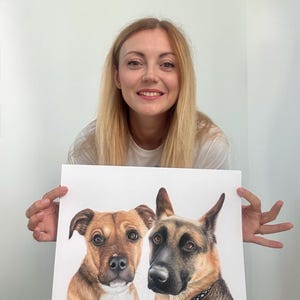 May include: A detailed colored pencil drawing of two dogs. One is a brown and white pit bull mix, and the other is a German Shepherd. The dogs are drawn on white paper.