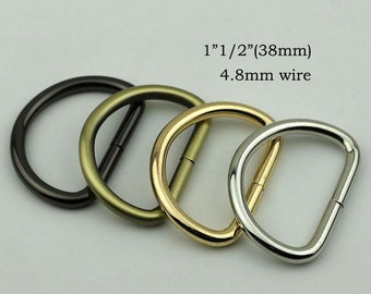 May include: Four D-rings in different finishes: black, antique brass, gold, and silver. Each ring is 1 1/2 inches (38 mm) in diameter and made with 4.8 mm wire.