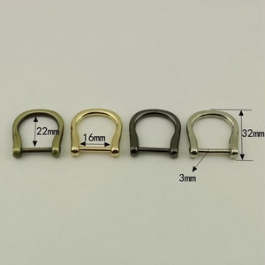 Puede incluir: Cuatro anillos en D de metal en diferentes acabados: latón antiguo, oro, plata y negro. Los anillos tienen un diámetro de 16 mm, 22 mm y 32 mm y un ancho de 3 mm.