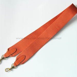 May include: Orange bag strap with gold-tone clasps and leather accents. The strap is made of a textured, woven material. The Etsy shop URL is visible in the image.