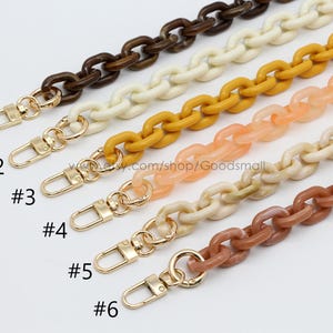May include: Six colorful acrylic chain straps with gold-tone clasps. The chains are in shades of brown, cream, yellow, peach, and tan. The image includes the numbers #1 through #6 next to each chain.