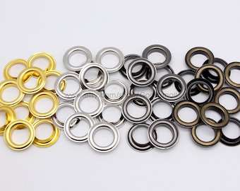 May include: Assortment of metal eyelets in gold, silver, and black. The eyelets are arranged in three groups, with each group containing eyelets of the same color.