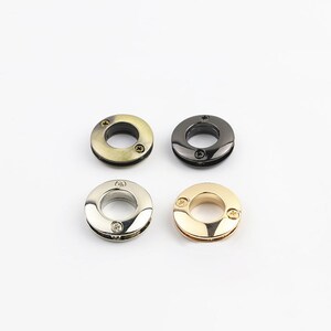 May include: Four metal rings with a screw closure. The rings are in four different finishes: gold, silver, antique brass, and black.
