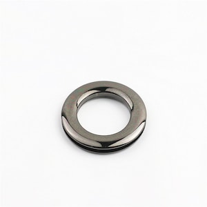 May include: A black metal ring with a smooth, shiny finish. The ring is about 1 inch in diameter and has a slightly raised edge.