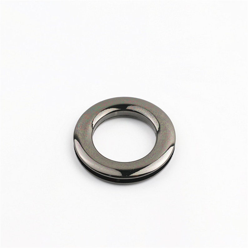 May include: A black metal ring with a smooth, shiny finish. The ring is about 1 inch in diameter and has a slightly raised edge.