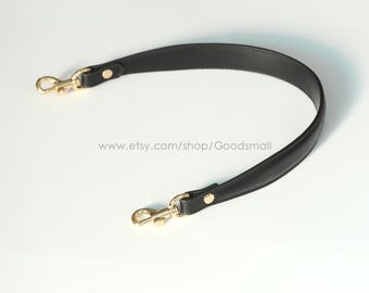 May include: A black leather bag strap with gold-colored metal clasps and hardware. The strap is curved and has a smooth texture. The Etsy shop URL is visible in the image.
