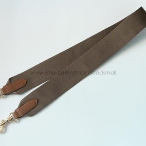 May include: A brown canvas bag strap with leather accents and gold-colored metal clasps. The strap is angled across a white background. The Etsy shop name www.etsy.com/shop/Goodsmall is visible.