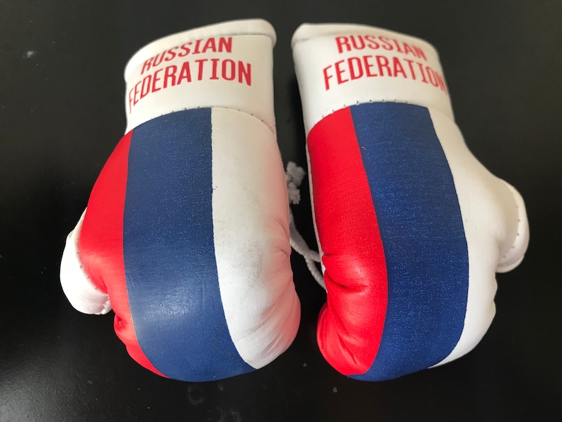 May include: A pair of white boxing gloves with the colours of the Russian flag and the text "RUSSIAN FEDERATION" on each glove.